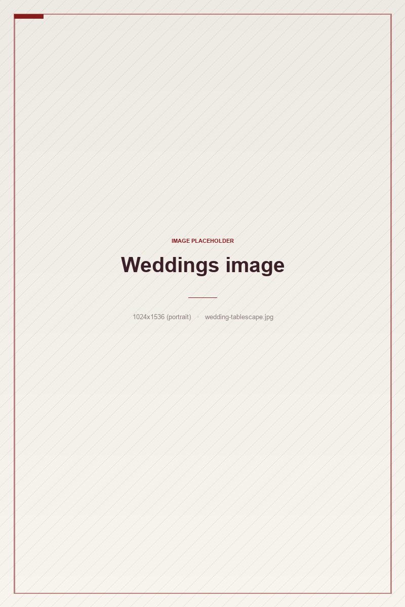 A layered ivory and garnet wedding tablescape with gold flatware and candle glow