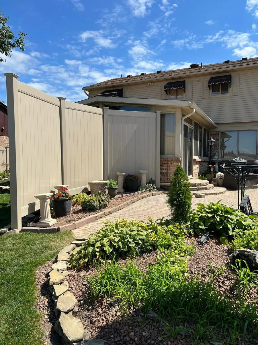 White vinyl privacy fence along a green backyard