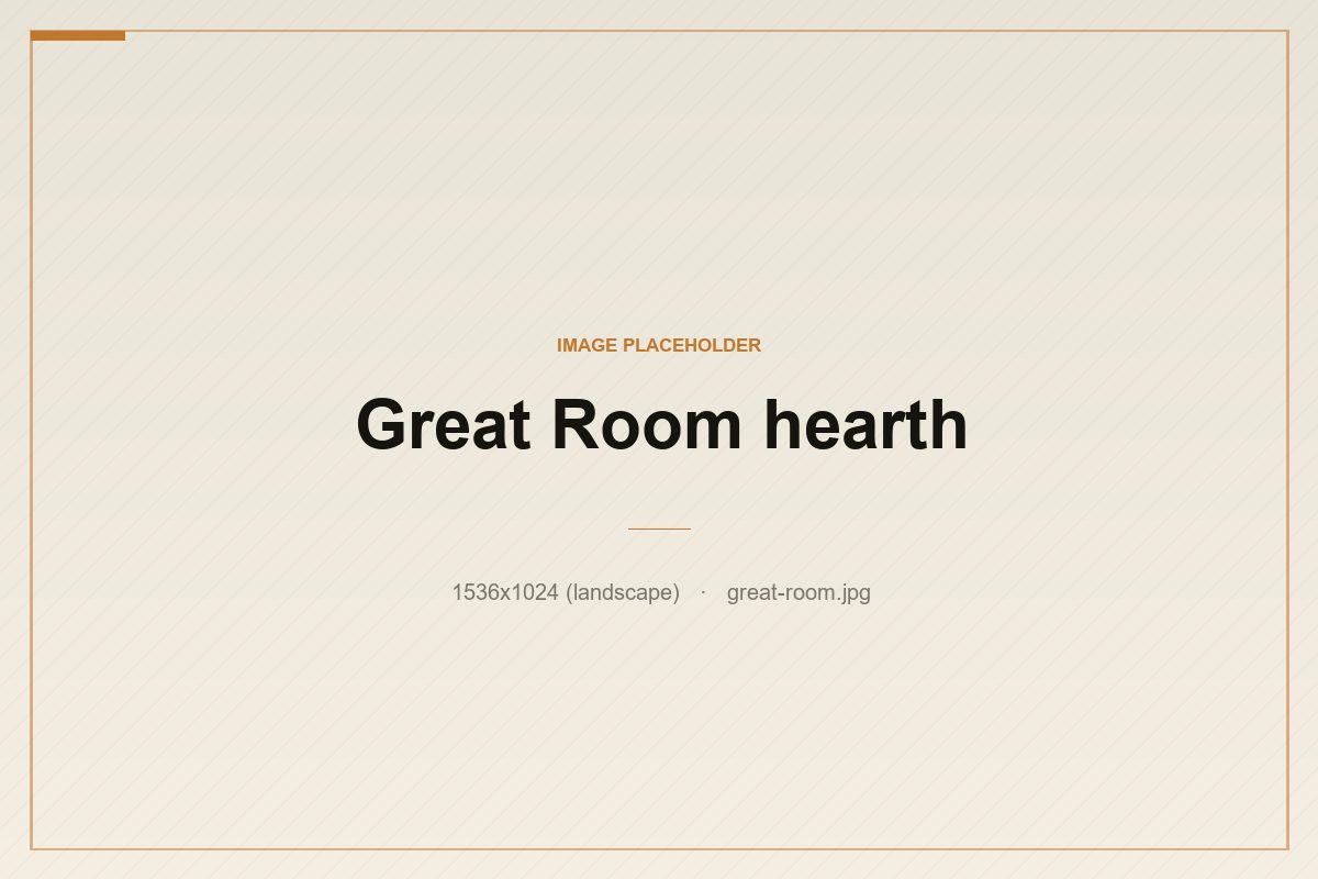 The Great Room hearth — blackened steel, leather, and a roaring fire